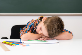 übermüdeter junge in der schule